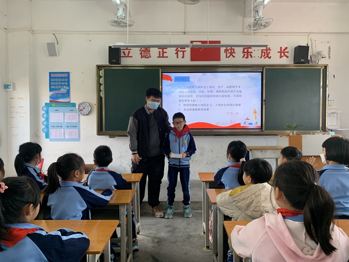2022年12月9日鎮(zhèn)司法所的副所長為回答正確的同學(xué)頒獎.jpg